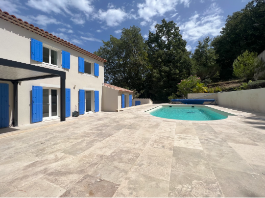 Vue extérieure de la villa avec ses volets bleus